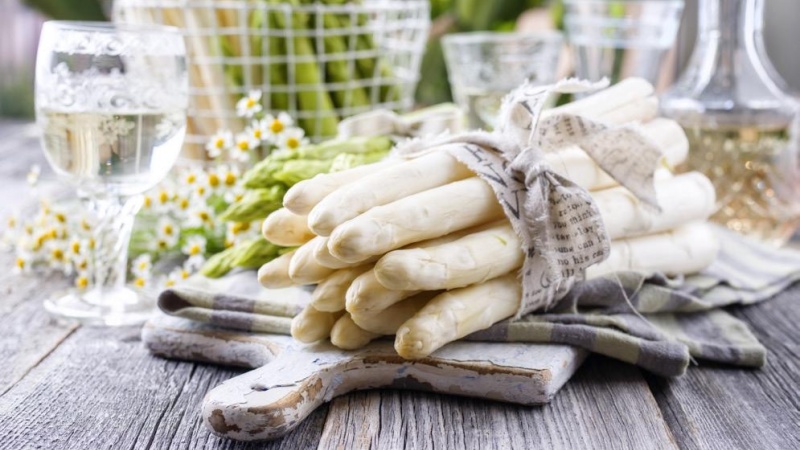 Vit sparris p� skarbrada med vinglas